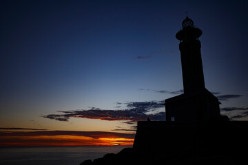 The Punta Nariga lighthouse on top of a rocky mountain by the sea