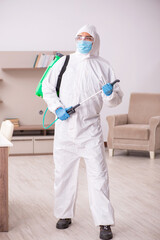 Fototapeta premium Young male contractor disinfecting at home