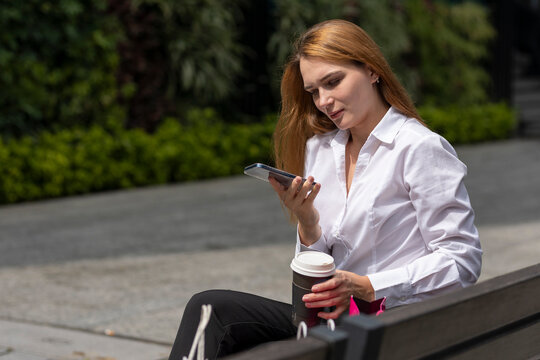 mujer sentada en una banca molesta, mandando mensajes por celular despues de hacer compras