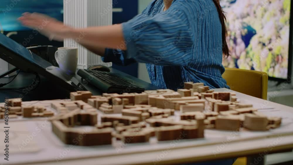 Poster close up of architectural desk with building model and touch screen monitor. woman architect analyzi