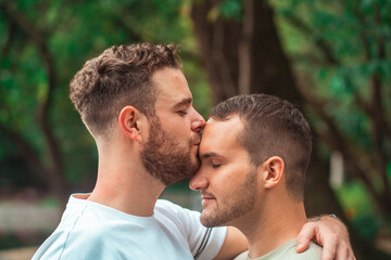 Fototapeta premium portrait of gay couple kissing on the forehead
