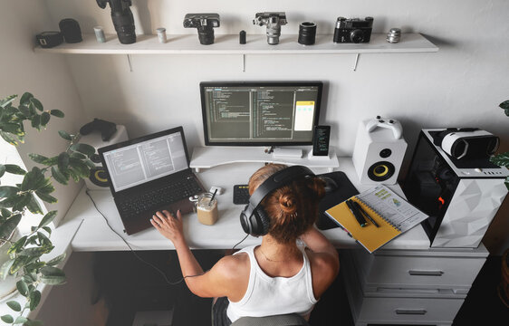 Girl programmer in the modern developer workplace for writing code with white computer desktop and comfy armchair.