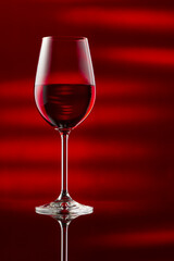 A glass of red wine on a glossy table.