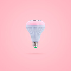 Pink color LED energy saving lamp 230v built-in wireless speakers isolated on pink pastel color background.