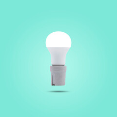 LED energy saving lamp 230v in a ceramic socket isolated on green pastel color background.