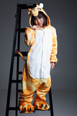 Cute Asian little girl wearing giraffe pajamas playing indoors
