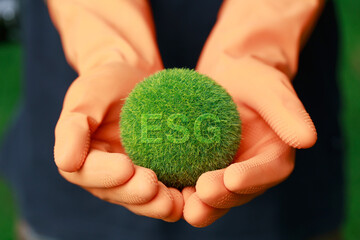 ESG Environmental, social, and corporate governance concept.Hands holding the green ball that writes the word ESG, Nature Сonservation, Ecology, Social Responsibility and Sustainability.