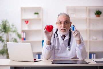 Old male doctor cardiologist working in the clinic