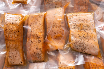 freeze cooked salmon in vacuum packs on grunge table, concept of food preservation, good work from home lunch idea, quick food on bysy day, time-saving meal for lockdown period