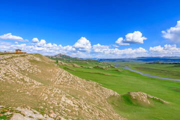 Fototapeta premium Green grassland and mountain natural landscape in Xinjiang,China.Beautiful prairie scenery.