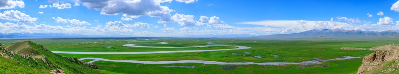 Bayinbuluke grassland natural scenery in Xinjiang,China.The winding river is on the green...