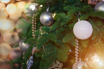 Fototapeta na wymiar holidays, new year, decor and celebration concept - close up of christmas tree decorated with balls and toys