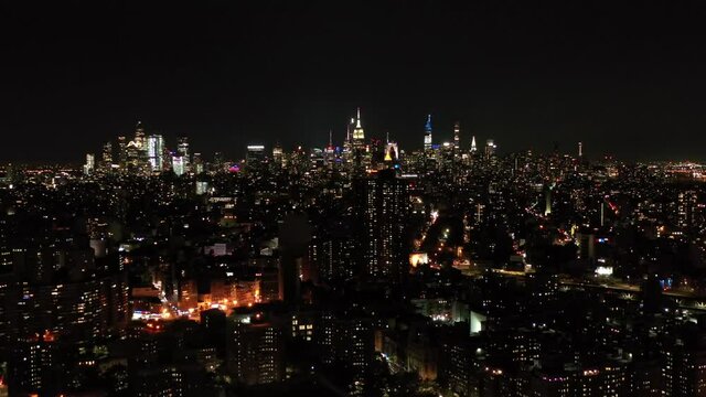 Drone Night Shot Of The New York City Manhattan Skyline, Empire State Building and housing projects at night