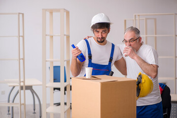 Two male professional movers drinking alcohol during break