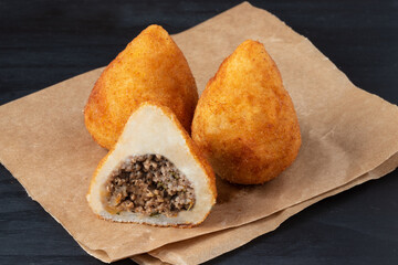 Brazilian meat coxinha on Kraft paper close up.