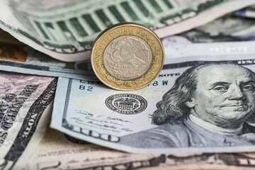 Eagle 10 peso coin on dollar bill
