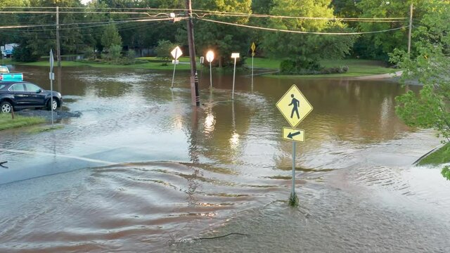 Pedestrian crossing crosswalk under flood water. Heavy rain hurricane tropical storm aftermath in USA, America.