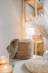 Light interior made of natural eco components. Wicker straw basket for storing clothes, Boho style room