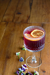 The concept of Georgian cuisine. Cool drink with ice made of fruit juice in a glass goblet with orange slice.