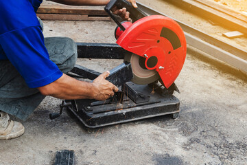 Worker man cutting steel with a circular steel cutter.