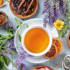 Tea with dry fruit, flowers, and herbs, square overhead shot with lavender and oranges