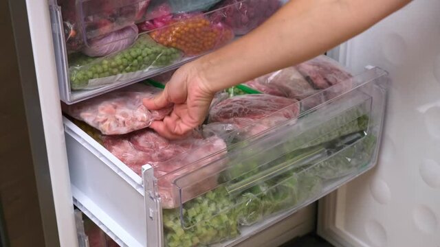 Frozen meat in plastic package in the freezer. Home stock shelf. Frozen food