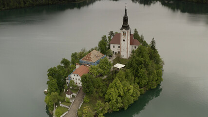Fototapeta na wymiar Aerial view over Bled lake Church, Slovenia Pilgrimage Church of the Assumption of Maria (Bled Island) on a Cloudy day,2021 