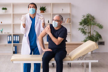 Old man visiting young doctor in covid-19 vaccination concept