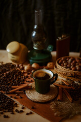 a cup of coffee on the background of coffee beans, kerasin lamp and cinnamon sticks