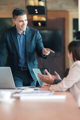 Young executive giving some new ideas about project to his partners in conference room.