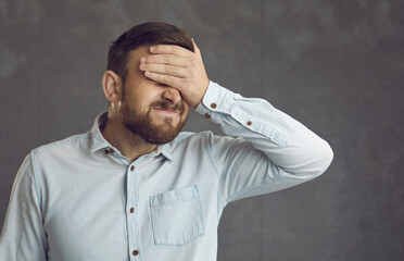 Businessman covers face with hand. Guy facepalms feeling ashamed of terrible mistake or poor...