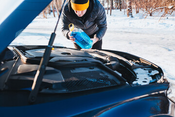 Replacing and refilling process fluids in the car - raised the engine hood for maintenance - replacing antifreeze and glass washer fluid