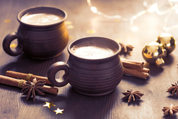 Two brown clay cups of black coffee,  Christmas decoration, spices on  the wooden table. Selective...