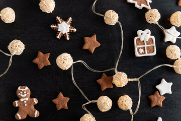 Garland and Christmas cookies glazed sugar icing on black background