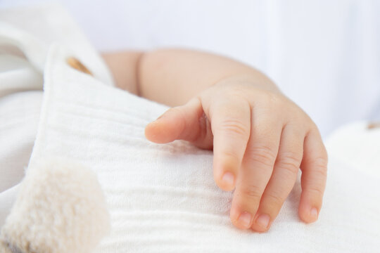 Closeup of a baby hand with white background. Macro picture during daylight, natural light.