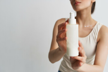woman in white t-shirt apply lotion on hand moisturizing clean skin