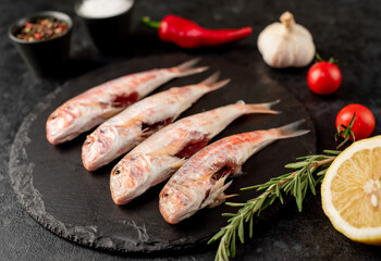 raw red mullet fish on stone background