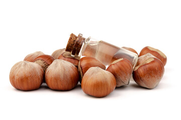 Hazelnut oil in glass bottle isolated on white background. Hazelnut background, healty food