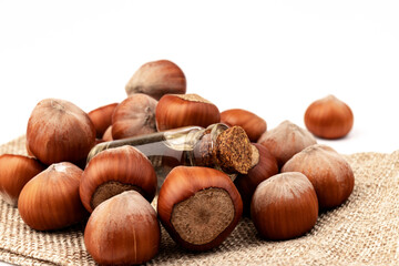 Hazelnut oil in glass bottle isolated on white background. Hazelnut background, healty food