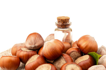 Hazelnut oil in glass bottle isolated on white background. Hazelnut background, healty food