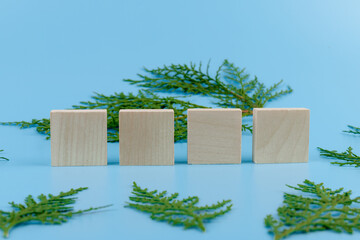 Four Wooden blocks whith cypress branches on a blue background. The concept of the New year, Christmas.