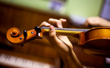 left hand of a young violinist holding the fretboard while playing violins, goizontal