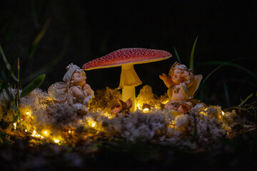 Fantasy Magical Mushrooms and elfs in enchanted Fairy Tale dreamy elf Forest with fabulous Fairytale moss and lights on mysterious Nature background and shiny glowing moon rays in night. High quality