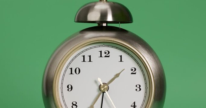 Close-up move camera - silver alarm clock isolated on green background, Showtime 01.36 am or pm, Second-hand minute Walk, Time concept.