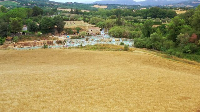 Aerial view of natural bath in tuscany, Italy. Hot cristalline water of spa. Saturnia natural spa with waterfalls and hot springs at Saturnia thermal baths, Grosseto,Tuscany. Beautiful panoramic shot.