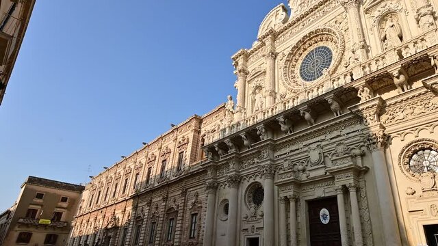 Lecce, Puglia, Italy. August 2021. The church of Santa Croce is the finest example of Lecce baroque. The pan footage displays it in all its beauty with late afternoon light.