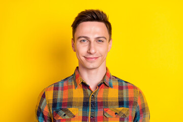 Obraz premium Portrait of attractive cheerful content brown-haired guy worker wearing checked shirt isolated over bright yellow color background