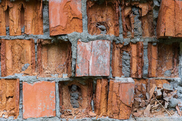 Fragment of a brick wall collapsing from external factors closeup