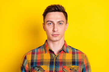 Fototapeta premium Portrait of attractive minded serious brown-haired guy wearing checked shirt isolated over bright yellow color background