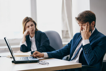 Fototapeta premium business man and woman in the office in front of a laptop career work officials